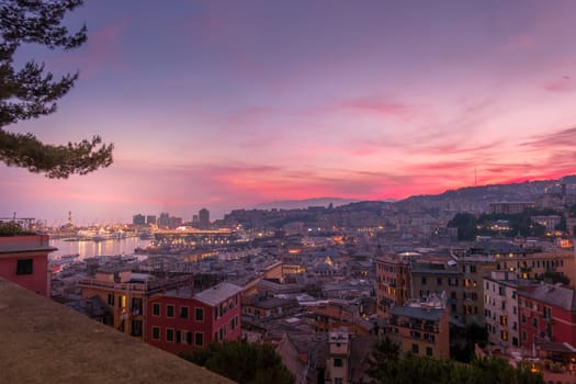 Genoa, Italy - 06 12 2021: Top view of the port of Genoa at sunset from Spianata Castelletto, with cruise ships and cityscape.