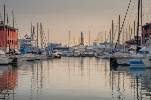 Genoa, Italy - 06 12 2021: View of the old port of Genoa at sunset with boats and Lanterna lighthouse.