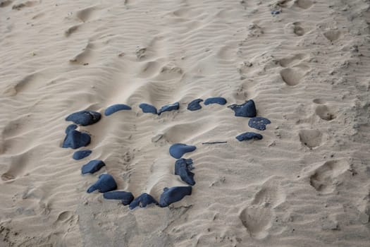 In the sandy beach was laid a heart of stones.