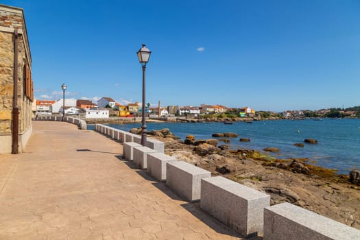 Galicia, Spain: 25 July 2022: Maritime scene of Arousa island with a small boats moored in the harbor.