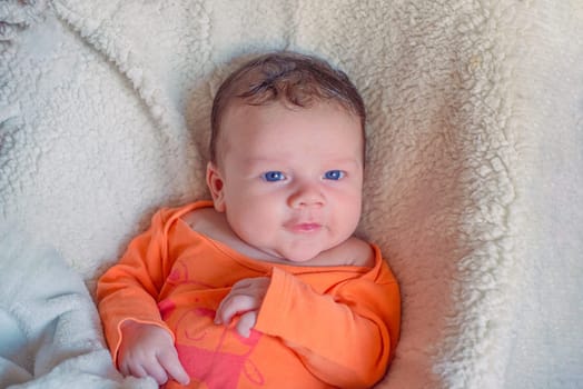 Newborn european white baby in orange clothes