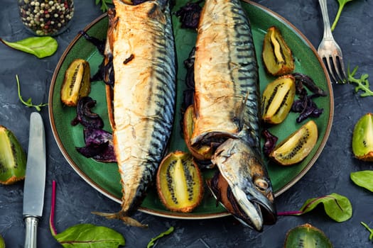 Whole mackerel fish baked with kiwi fruits. BBQ grilled mackerel fish