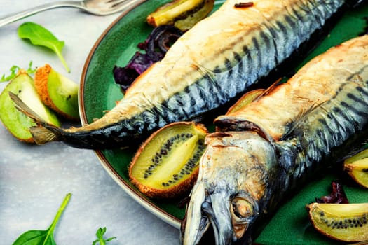 Whole mackerel fish baked with kiwi fruits. BBQ grilled mackerel fish