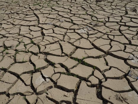 Deep cracks in the land as a symbol of hot climate and drought. Desert and cracked ground. Uneven, swollen ground. Emptiness and death. Ecological and natural theme