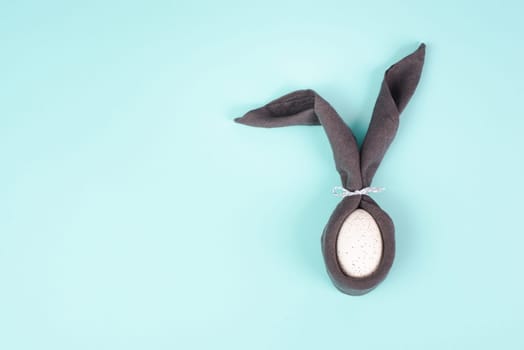 Easter bunny, wrapped egg with a cloth, minimal spring holiday concept