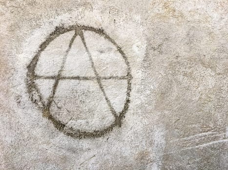Grungy anarchy symbol on wall. Ideal for textures, backgrounds and concepts. Space for text.