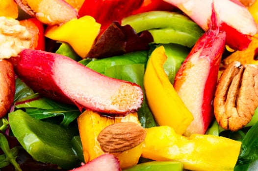 Vitamin homemade salad of rhubarb, bell pepper, greens and nuts on a plate