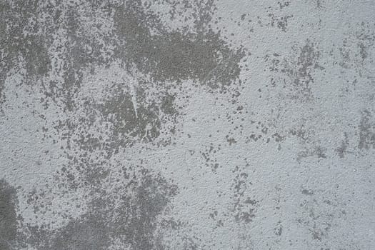 Plastered wall texture. Whitewash surface. Abstract background. Retro wall built structure texture. Cracks and bumps on the concrete wall. Uneven coloring with water-based paint. Old tattered plaster.