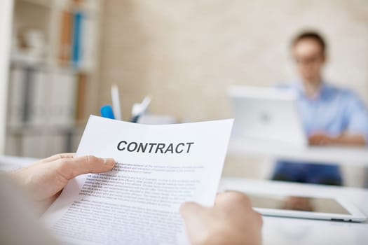 Contract in businessman hands in working environment