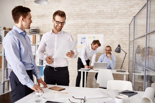 Young colleagues interacting at meeting in office