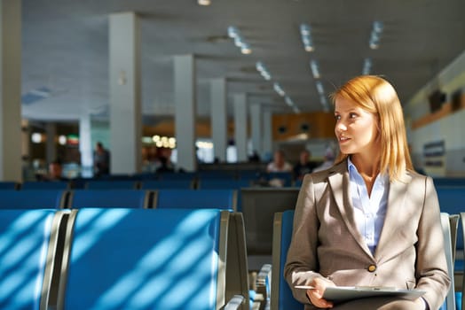 Young businesswoman with clipboard sitting in airport