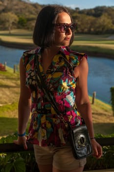Young woman in sunglasses enjoying summer breeze at the beach. Closeup