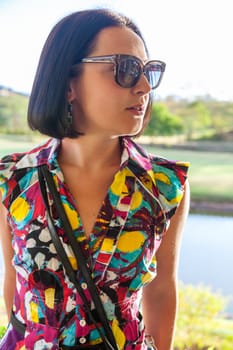Young woman in sunglasses enjoying summer breeze at the beach. Closeup