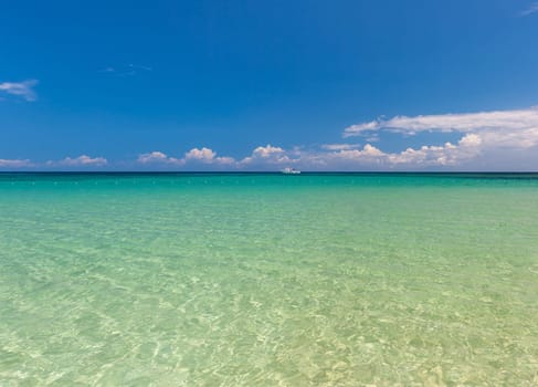 Beach on the tropical island. Clear blue water, blue sky. Beautiful vacation spot.