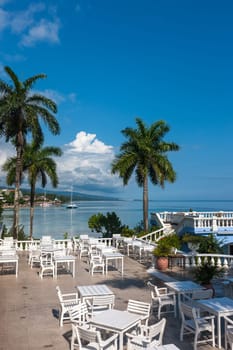White tables and chairs  in tropical garden  on a beautiful  beach of Jamaica