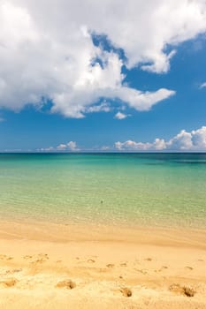 Beach on the tropical island. Clear blue water, sand and clouds. Beautiful vacation spot.