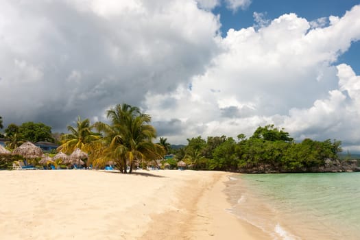 Beach on the tropical island. Clear blue water, sand and clouds. Beautiful vacation spot.