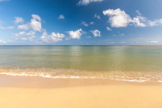 Beach on the tropical island. Clear blue water, sand and clouds. Beautiful vacation spot.