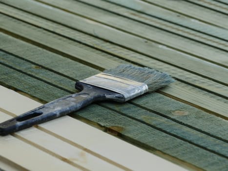 wide paint brush painting wooden boards