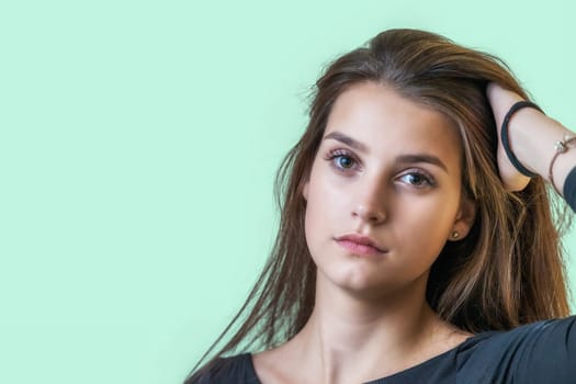 Portrait of beautiful girl on the green background. Horizontally.
