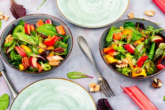 Vitamin delicious salad of rhubarb, bell pepper, herbs and nuts in bowl. Space for text