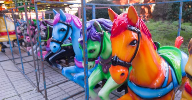 Horses out of merry-go-round placed on line. Long format