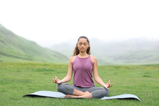Front view portrait of a yogi doing yoga a foggy day