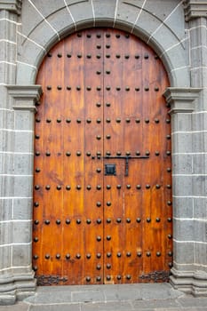 Old massive large wooden door in a stone wall of a church.