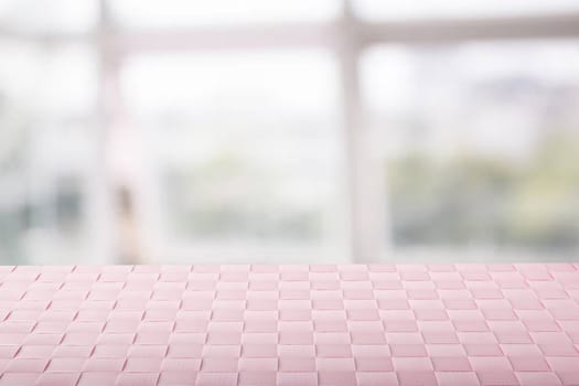 Empty table product. Closeup of a empty pink tablecloth or napkin on table over abstract blurred bright windows background. Template for your food and product display montage.