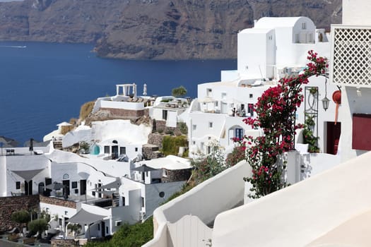 Oia, Santorini, Greece - July 3, 2021: Whitewashed houses with terraces and pools and a beautiful view in Oia on Santorini island, Greece
