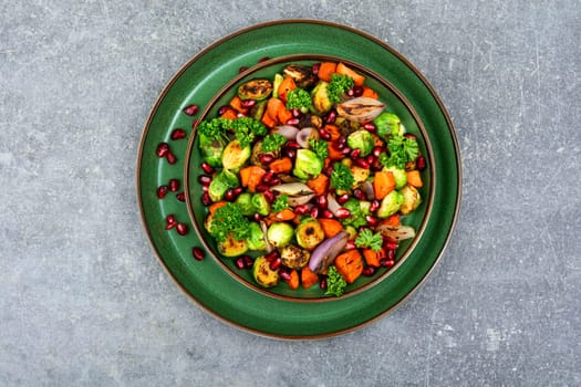 Salad with Brussels sprouts, carrots, with parsley and pomegranate seeds. Healthy vegetarian food