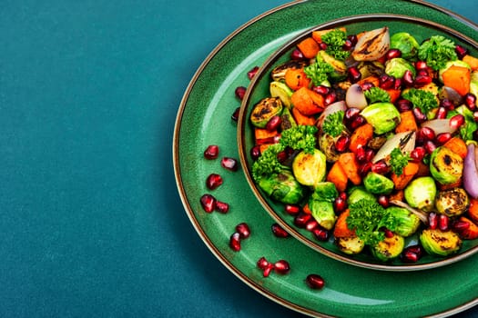 Salad with Brussels sprouts, carrots, with parsley and pomegranate seeds. Healthy vegetarian food