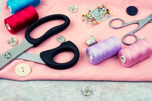 Home needlework kit, scissors, needles, buttons and bobbins with thread