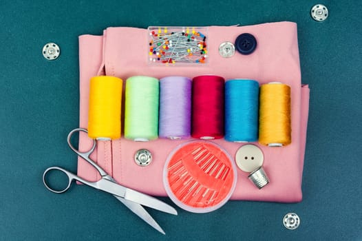 Home needlework kit, scissors, needles, buttons and bobbins with thread