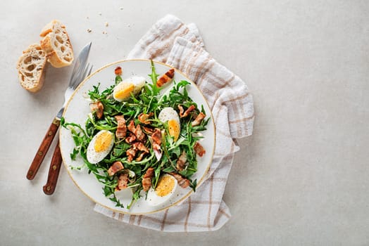 Dandelion salad with egg and roasted bacon on plate