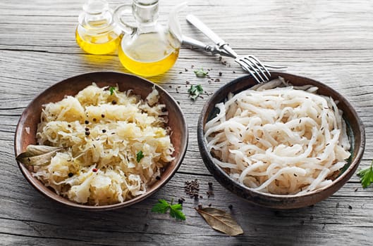 Traditional fresh and healthy sauerkraut and sour turnip on wooden background.