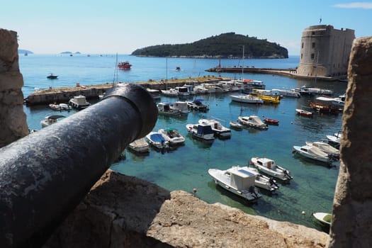 Dubrovnik, Croatia, 08.14. 2022 City port summer tourist attraction. Tourists walk, get into boats and ships and go on boat trips. Adriatic Sea. Travel. Cannon muzzle. Private boats of local citizens