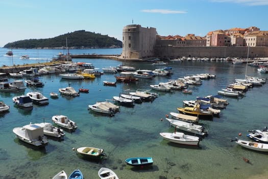 Dubrovnik, Croatia, 08.14. 2022 City port summer tourist attraction. Tourists walk, get into boats and ships and go on boat trips. Adriatic Sea. Travel and recreation. Private boats of local citizens