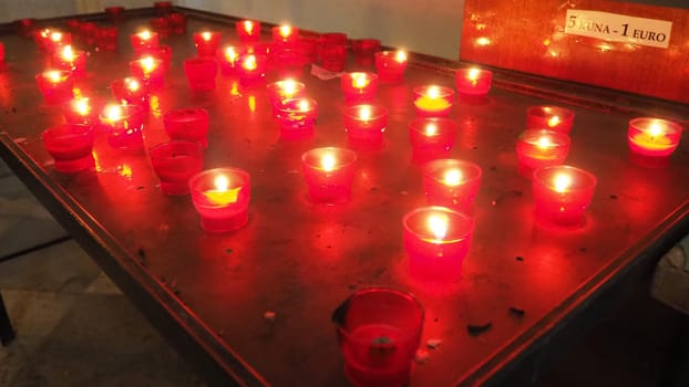 Memorial Day with candle. Commemorative candles are lit. Candle flames burn in the cemetery. Burning candles in the catholic church in Dubrovnik Croatia. Lots of candles. The flame sways in the draft