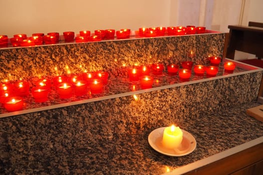 Memorial Day with candle. Commemorative candles are lit. Candle flames burn in the cemetery. Burning candles in the catholic church in Dubrovnik Croatia. Lots of candles. The flame sways in the draft