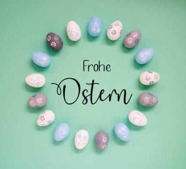 Flat Lay With German Text Frohe Ostern Means Happy Easter. Easter Egg Arrangement, Decoration And Ornament. Light Green Paper Background
