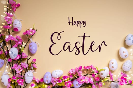 English Text Happy Easter On Beige Background. Pink And Purple, Shiny And Bright Spring Flower Arrangement With Easter Egg Decoration.