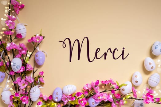 French Text Merci Means Thank You On Beige Background. Pink And Purple, Shiny And Bright Spring Flower Arrangement With Easter Egg Decoration.