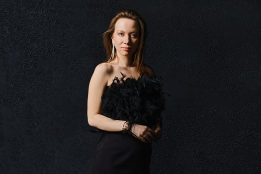 Low key photo of elegant woman in corset posing on black background