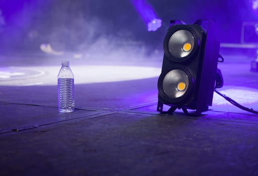 Bottle of water over stage beside light .stage blinder. Selective focus