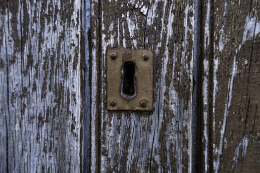 Detail of old and abandoned lock on a wooden door, ruin