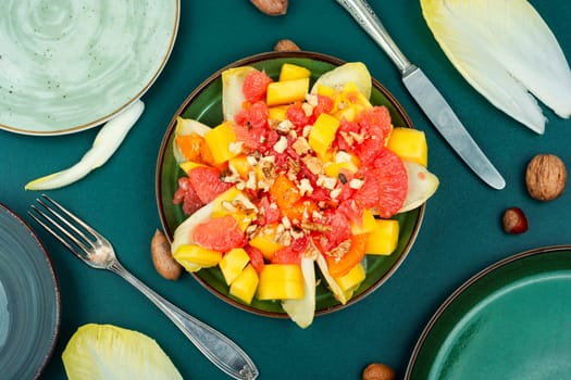 Fresh chicory salad with fruits and walnut. Healthy meal recipe