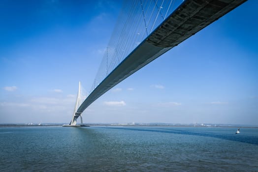 pillar of the bridge "Pont de Normandie"" reflected in the Seine river at Le Havre, France"