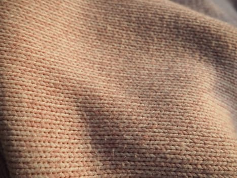Knitted knitwear. Knitted warm winter sweater or close-up jumper. Wool or polyester threads. Clothing production. The texture of the knitted thing.