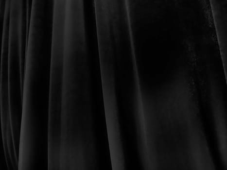 Soft waves on black velvet curtains. Stylized defocused image. Dark draperies made of pleasant fabric. Pleats on the curtains. Abstract black and gray background